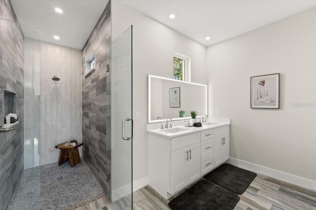 bathroom with vanity, a shower with shower door, and wood-type flooring