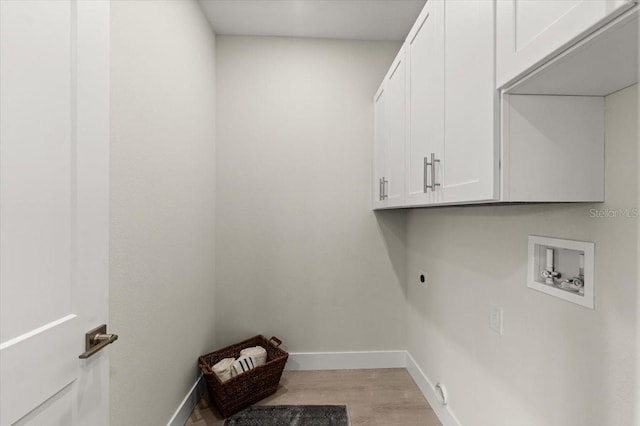 clothes washing area featuring cabinets, hookup for a washing machine, light hardwood / wood-style flooring, and electric dryer hookup