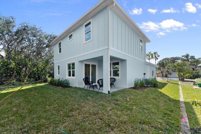 rear view of house with a lawn and a patio area