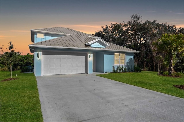 72 Aurora Ave, Ponce Inlet, FL 32127 - view of front of property with a standing seam roof, a garage, a lawn, concrete driveway, and metal roof