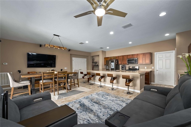 living room featuring ceiling fan and light hardwood / wood-style floors