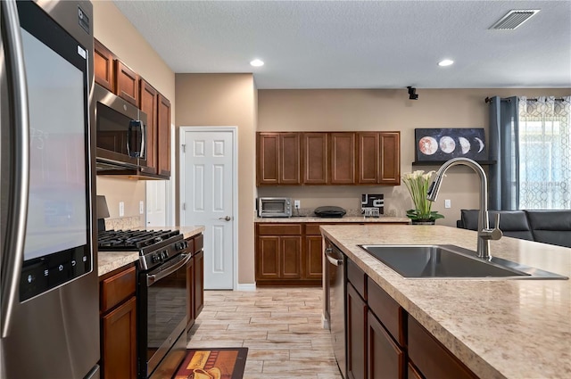 kitchen featuring appliances with stainless steel finishes, sink, and a textured ceiling