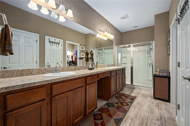 bathroom with hardwood / wood-style flooring, vanity, and an enclosed shower