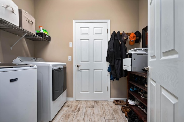 clothes washing area featuring independent washer and dryer and light hardwood / wood-style flooring