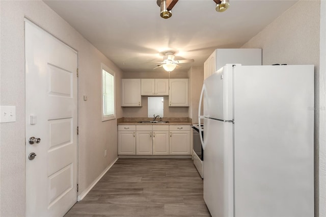 kitchen with sink, electric range oven, white fridge, light hardwood / wood-style floors, and white cabinets