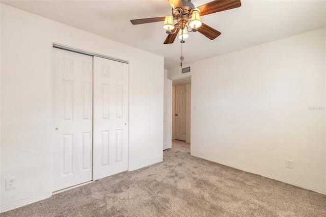 unfurnished bedroom with light colored carpet, ceiling fan, and a closet