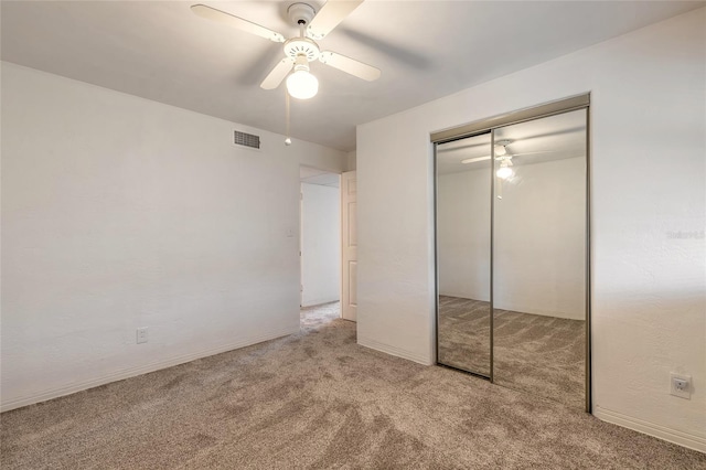 unfurnished bedroom with light colored carpet, a closet, and ceiling fan