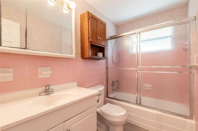 full bathroom with toilet, tasteful backsplash, tile walls, vanity, and enclosed tub / shower combo