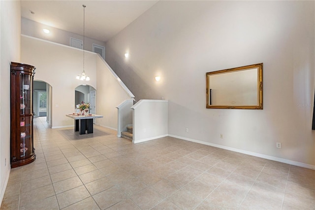 additional living space with light tile patterned floors and a high ceiling