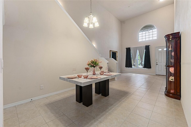 entryway featuring a notable chandelier, light tile patterned flooring, and a high ceiling