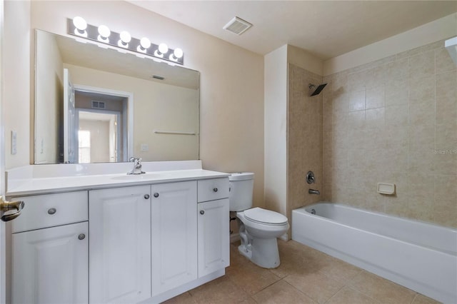 full bathroom with tile patterned flooring, tiled shower / bath, vanity, and toilet