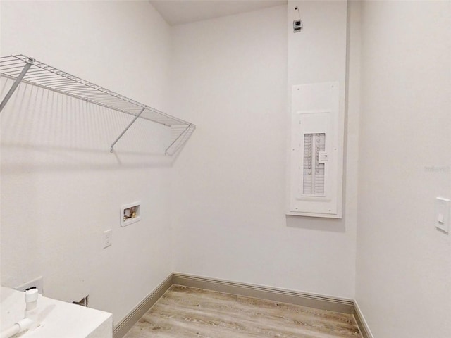 clothes washing area featuring laundry area, baseboards, hookup for a washing machine, and light wood-style floors