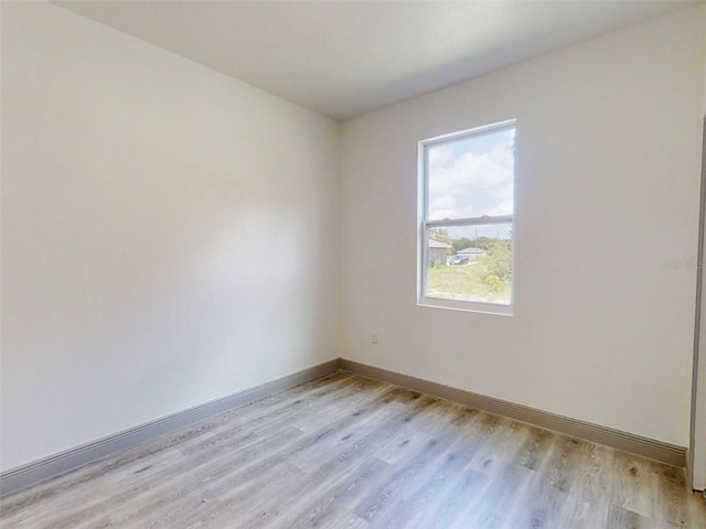 unfurnished room with light wood-style floors and baseboards