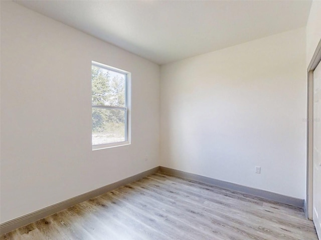 empty room with light wood-type flooring and baseboards