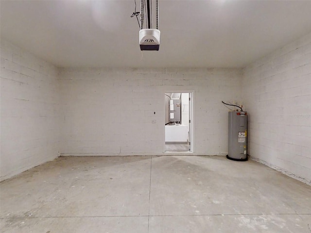 garage featuring water heater, concrete block wall, and a garage door opener