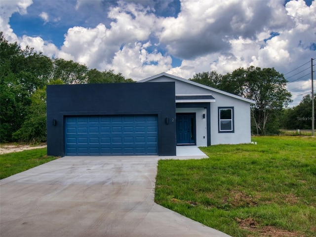 view of front of property with driveway, a garage, stucco siding, and a front yard