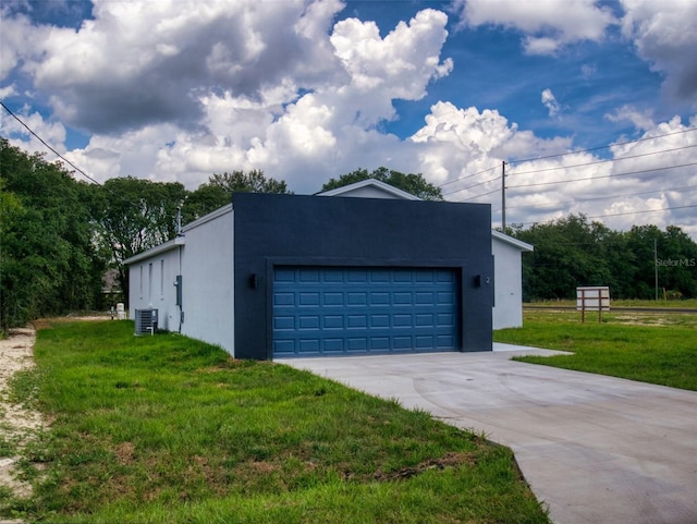 exterior space with a yard, central air condition unit, a garage, and stucco siding