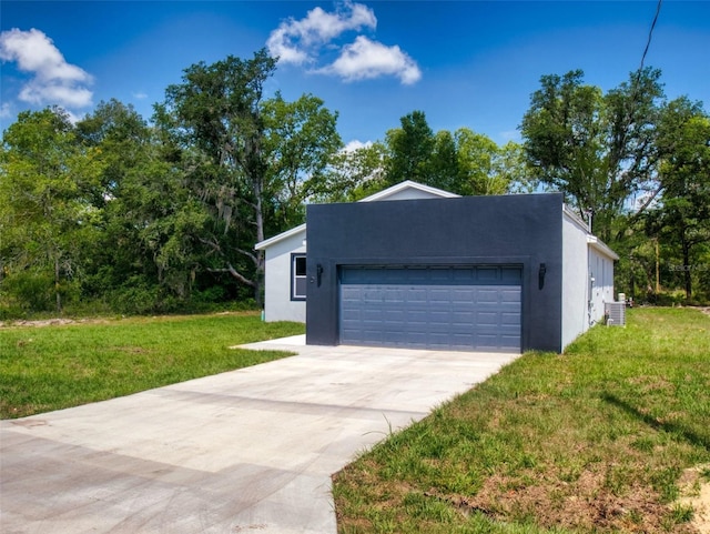 exterior space featuring a front yard, an attached garage, driveway, and stucco siding