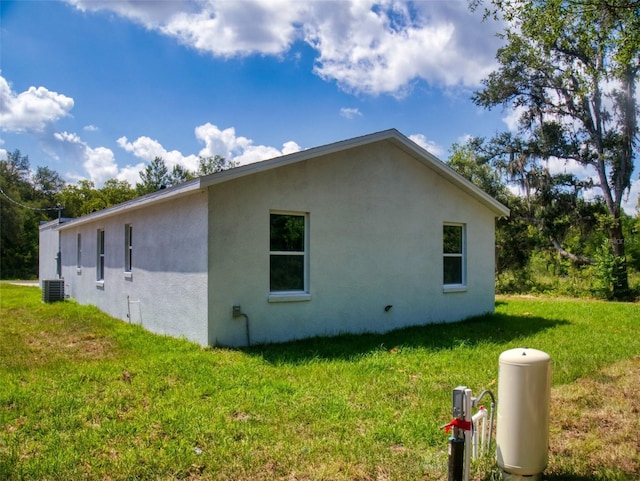 view of home's exterior featuring cooling unit, a lawn, and stucco siding