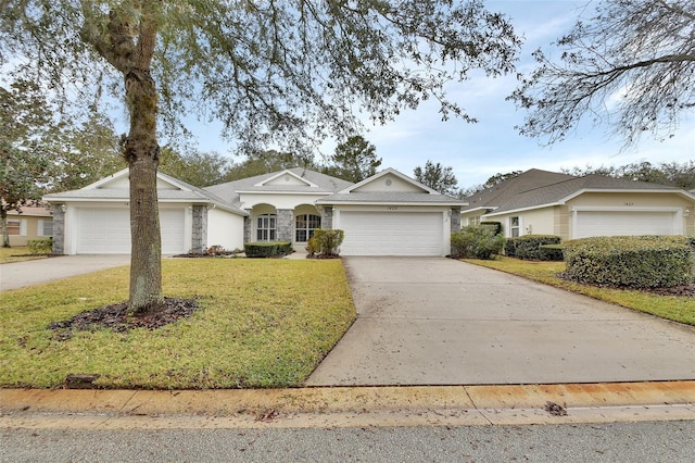 single story home with stone siding, a front yard, concrete driveway, and an attached garage