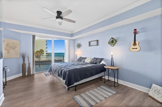 bedroom with hardwood / wood-style floors, a water view, access to outside, and ceiling fan