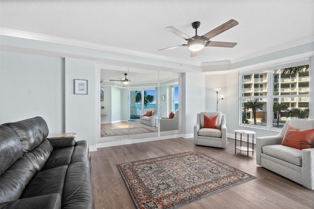 living room featuring crown molding, ceiling fan, dark hardwood / wood-style floors, and a textured ceiling