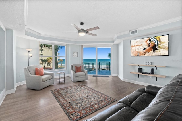 living room featuring plenty of natural light, wood-type flooring, and a water view