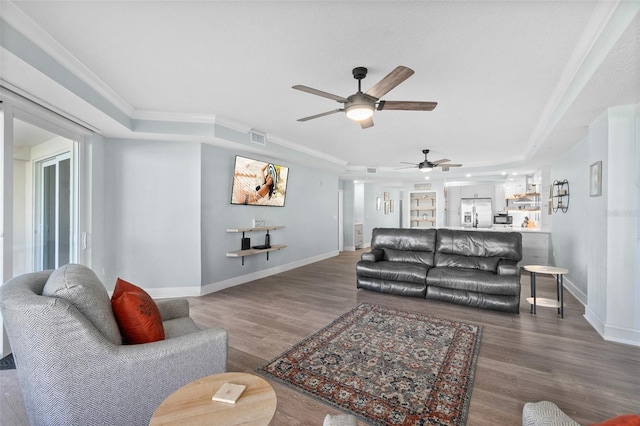 living room featuring crown molding, ceiling fan, a raised ceiling, and hardwood / wood-style floors