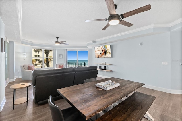 dining space featuring crown molding, hardwood / wood-style floors, and a textured ceiling