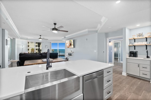 kitchen featuring sink, light hardwood / wood-style floors, white cabinets, stainless steel dishwasher, and a raised ceiling