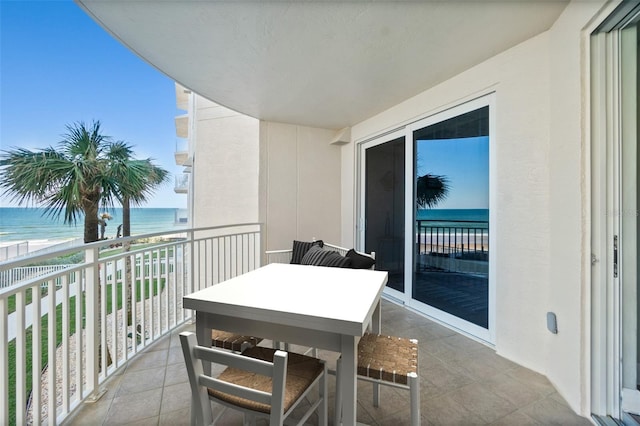 balcony with a water view and a beach view