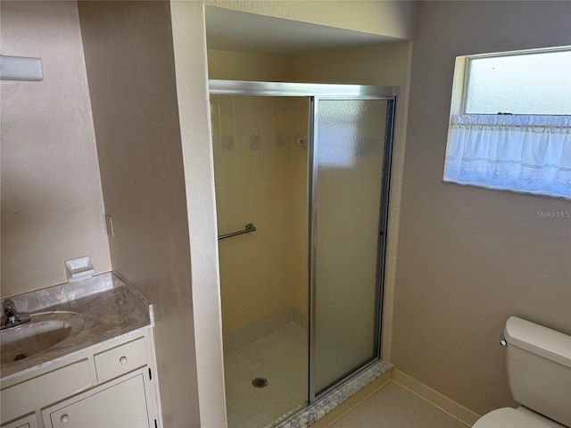 full bathroom featuring toilet, a shower stall, vanity, baseboards, and tile patterned floors