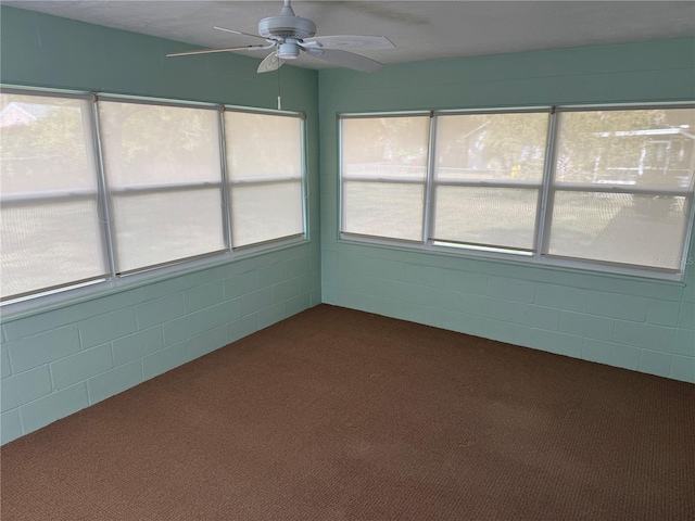 unfurnished sunroom featuring a ceiling fan