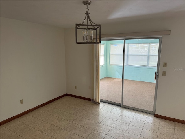 unfurnished dining area featuring a notable chandelier and baseboards