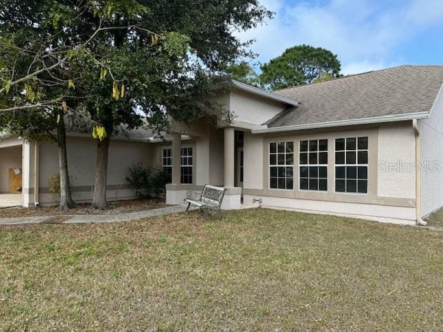 rear view of property featuring a yard