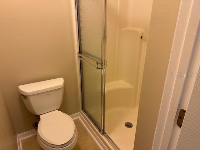 bathroom featuring walk in shower and toilet