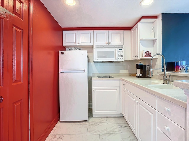 kitchen with sink, white appliances, and white cabinets