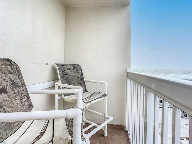 balcony featuring a view of the beach and a water view