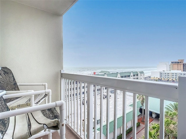 balcony featuring a view of the beach and a water view