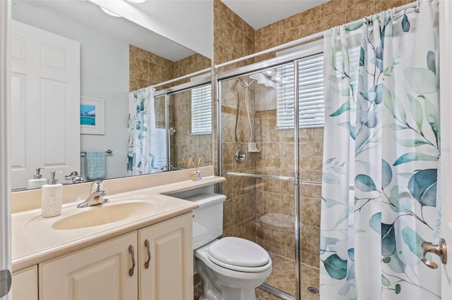 bathroom with vanity, a tile shower, and toilet