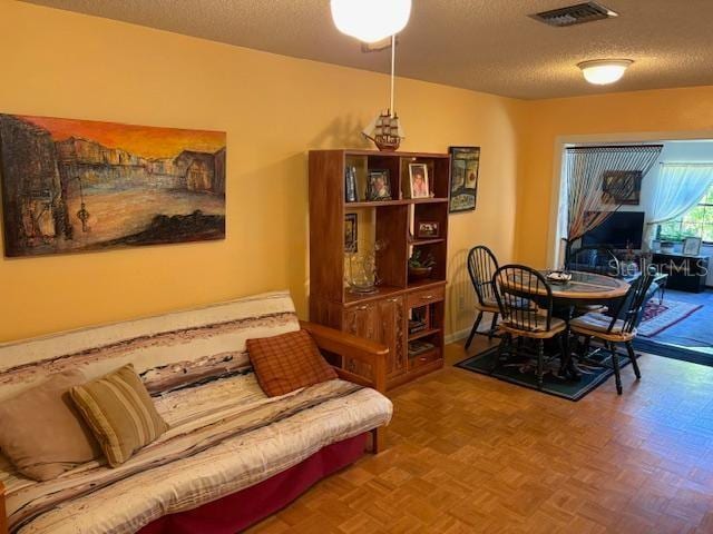 dining room featuring parquet flooring and a textured ceiling