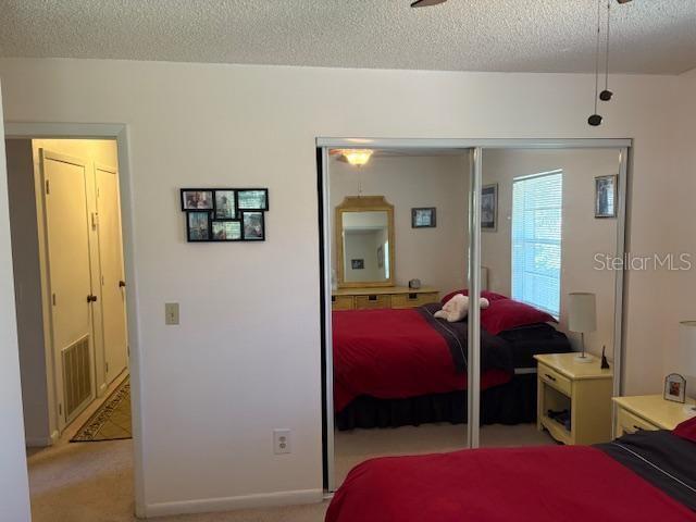 carpeted bedroom featuring a closet and a textured ceiling