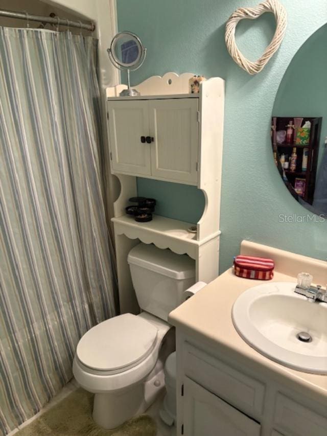 bathroom featuring vanity, toilet, and a shower with shower curtain