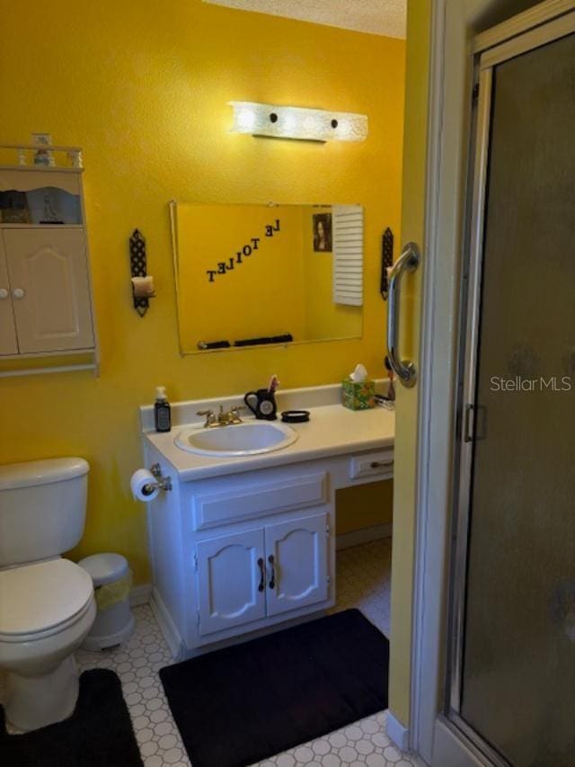 bathroom featuring an enclosed shower, vanity, and toilet