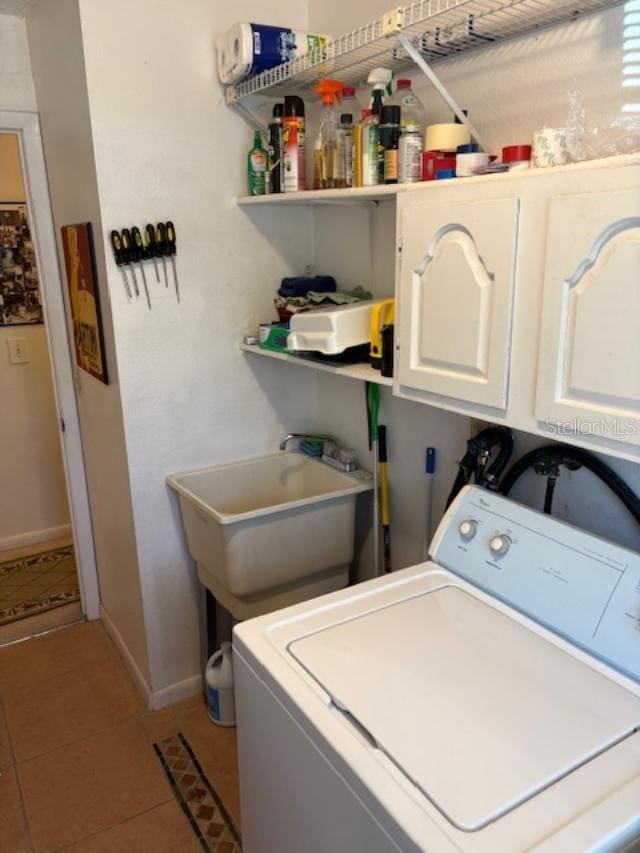 washroom with sink, washer / dryer, cabinets, and light tile patterned flooring