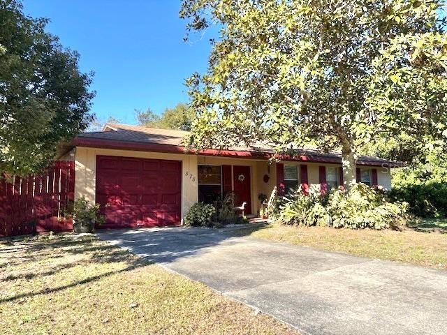 single story home featuring a garage and a front yard