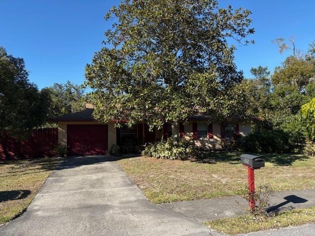 obstructed view of property with a garage and a front lawn