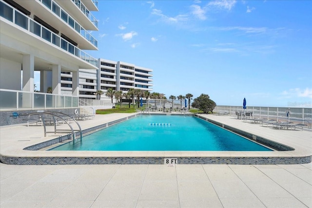 view of pool featuring a patio and a water view