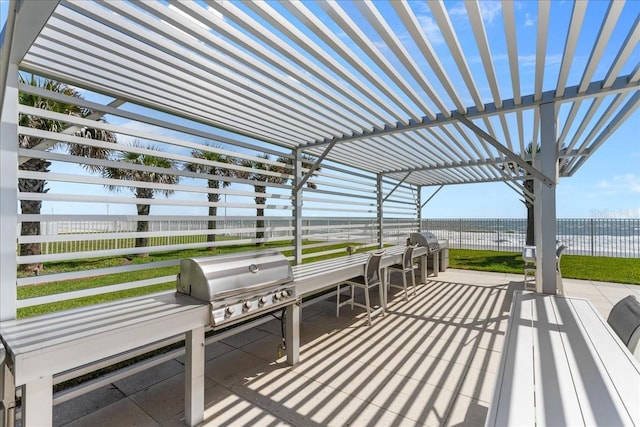 view of patio with area for grilling, a grill, a pergola, and a water view