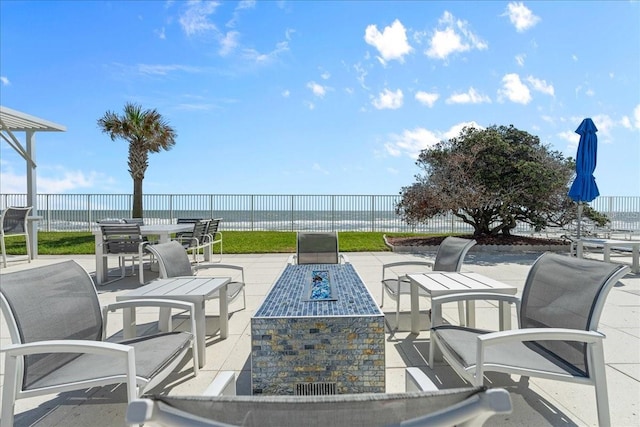 view of patio featuring an outdoor fire pit and a water view